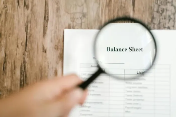 Magnifying Glass inspecting a balance sheet