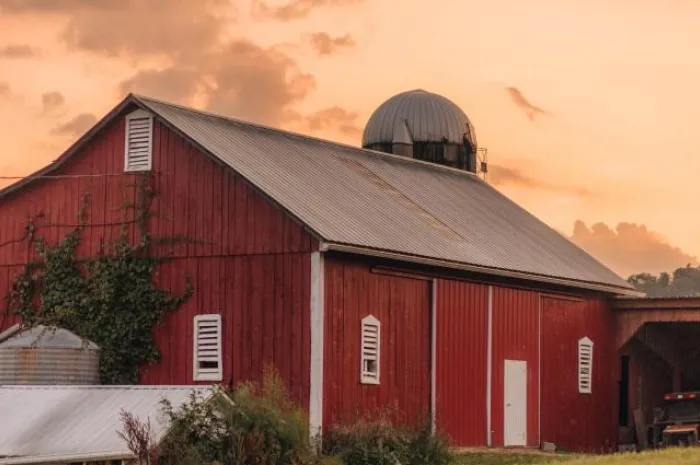 A red barn against a sunset